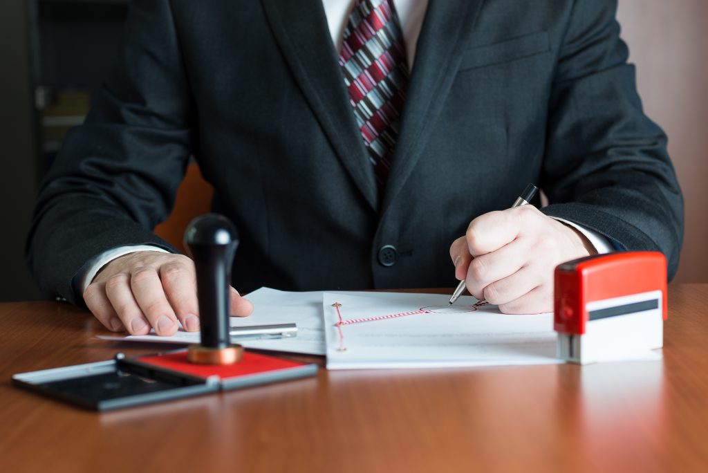 Notary Public in his office signing a contract